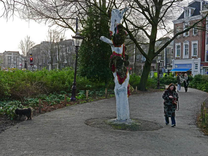 A person walking a path in a park, with a dog nearby