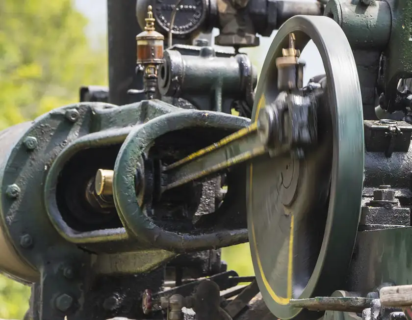 People gathered around antique tractors at an outdoor farm show